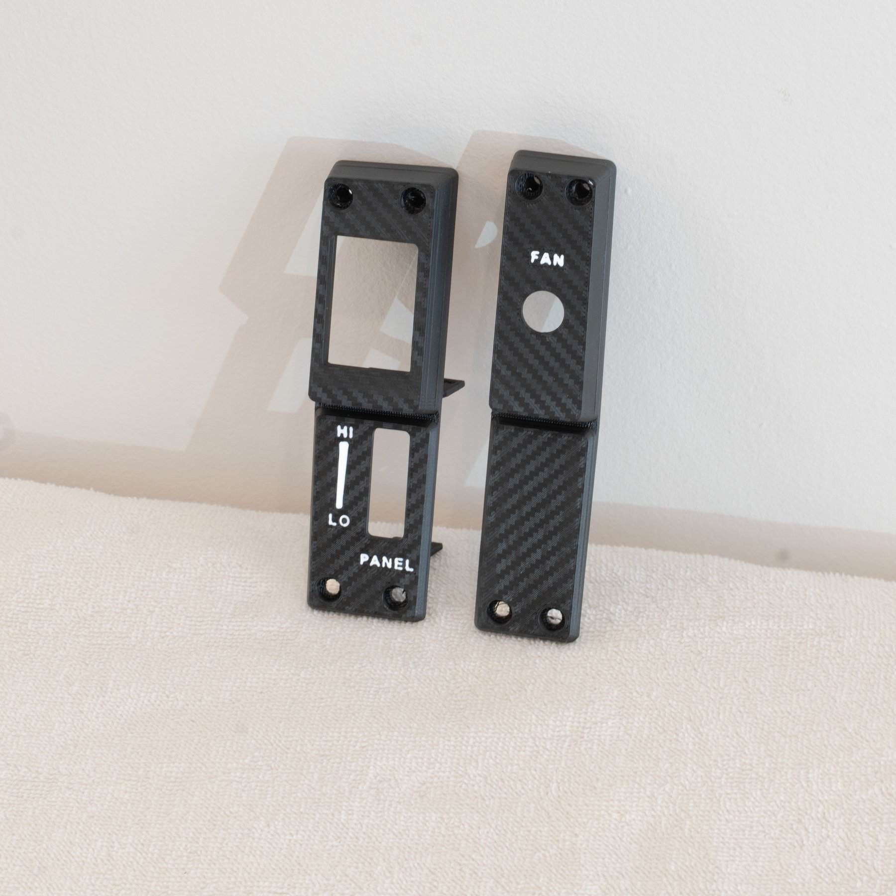 Reproduction Fiero driver-side cluster panel with white HI, LO and PANEL text beside the passenger-side panel, carbon weave finish