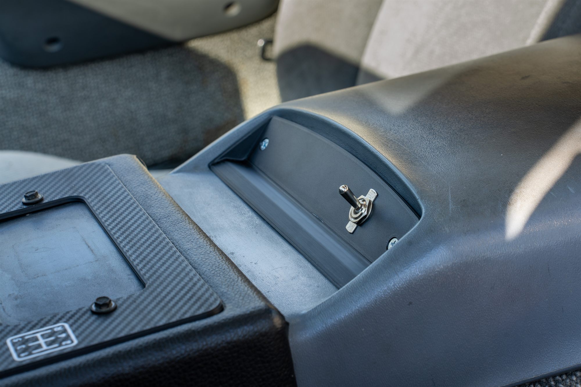 Smooth finish Fiero lighter bezel with toggle switch installed in the console