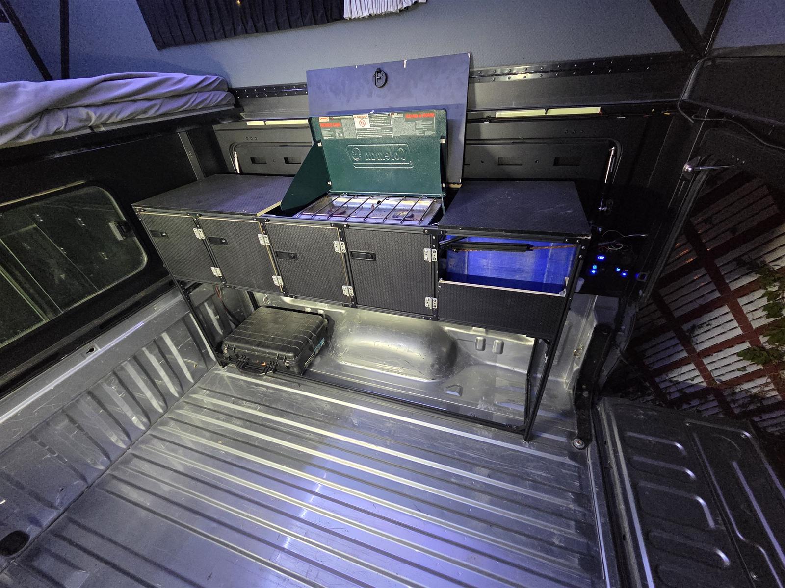 Removable galley cabinet with a camp stove inside a pop-up truck camper
