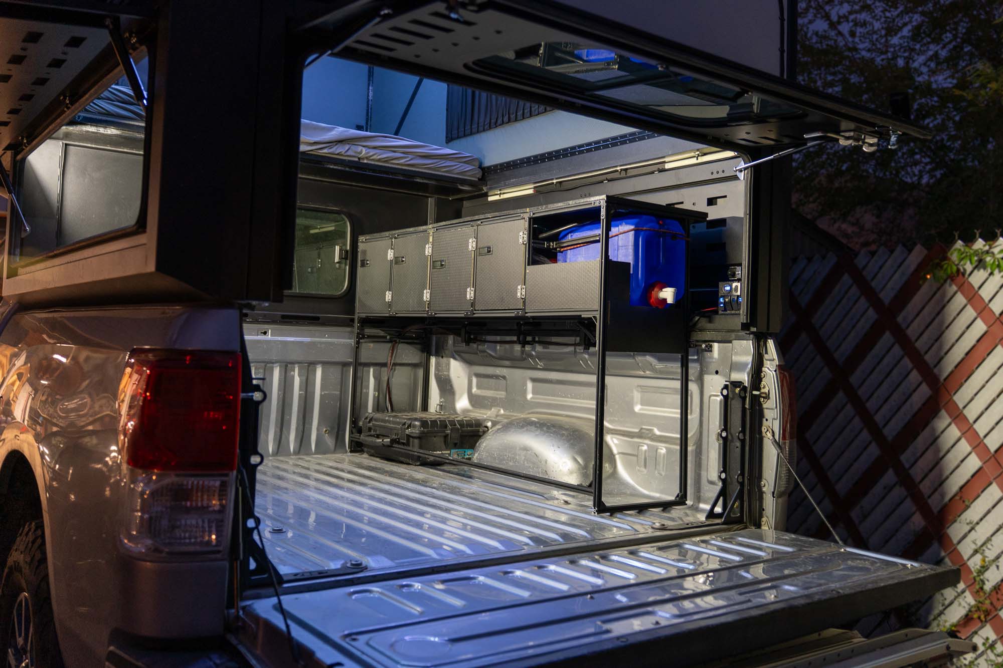 Pop-up truck camper with the tailgate down and a removable galley cabinet installed in the bed